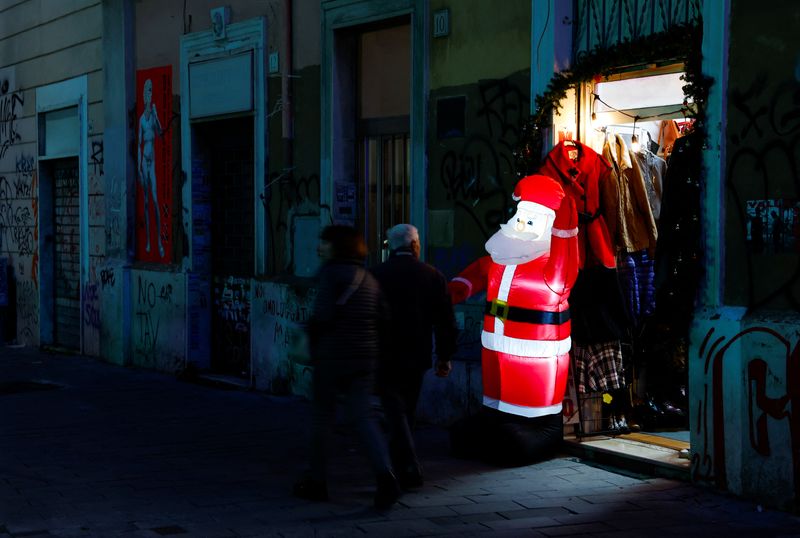 © Reuters. FILE PHOTO: People walk next to closed shops in Rome, Italy, December 6, 2023. REUTERS/Remo Casilli/File Photo