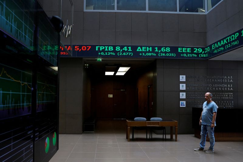 &copy; Reuters. FILE PHOTO: A man stands under a stock ticker showing stock options inside the Athens stock exchange building in Athens, Greece, August 20, 2018. REUTERS/Alkis Konstantinidis/File Photo