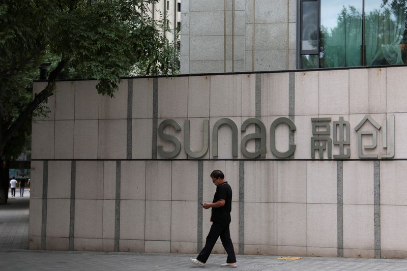 © Reuters. FILE PHOTO: A man walks past the logo of real estate developer Sunac at a residential complex in Beijing, China September 19, 2023. REUTERS/Florence Lo/File Photo