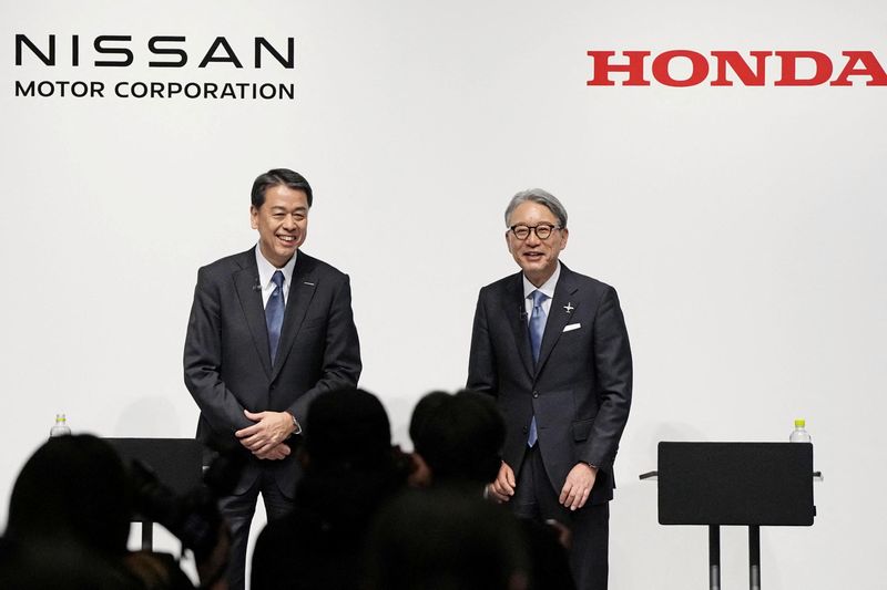 © Reuters. FILE PHOTO: Nissan Motor Chairman and CEO Makoto Uchida and Honda Motor Chairman and CEO Toshihiro Mibe attend their joint news conference in Tokyo, Japan March 15, 2024. Mandatory Credit Kyodo/via REUTERS/File Photo