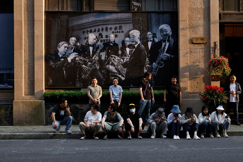 © Reuters. FILE PHOTO: People rest on a street in Shanghai, China May 24, 2021. REUTERS/Aly Song/File Photo