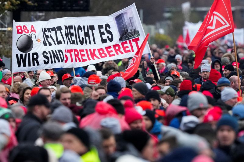 © Reuters. FILE PHOTO: VW employees attend an IG Metall union rally in front of Volkswagen headquarters, during a warning strike at the main factory of Germany's carmaker in Wolfsburg, December 9, 2024. Banner reads, 