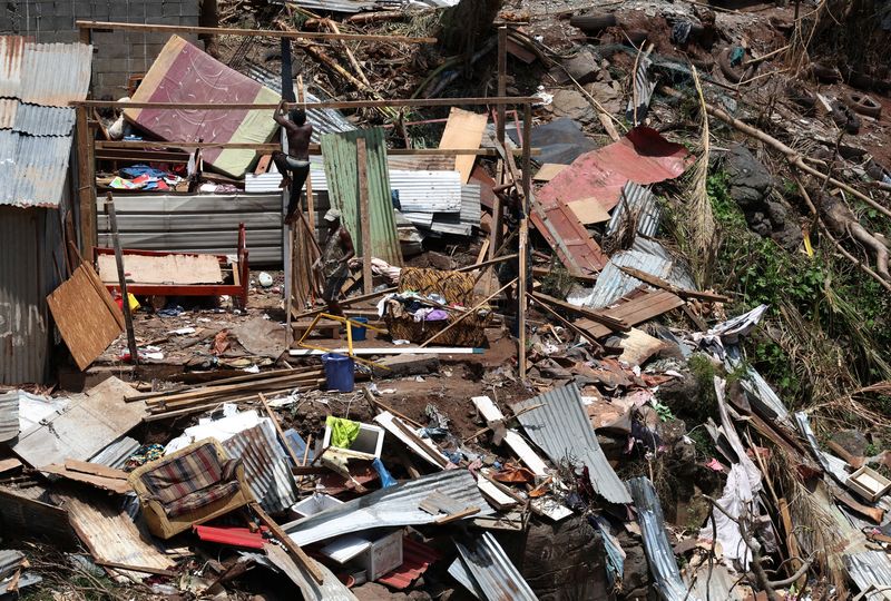 © Reuters. A man inspects a destroyed house in the aftermath of Cyclone Chido, in Kaweni, Mayotte, France, December 18, 2024. REUTERS/Yves Herman