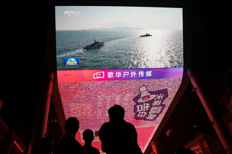 © Reuters. FILE PHOTO: A giant screen shows news footage of military drills conducted in the Taiwan Strait and areas to the north, south and east of Taiwan, by the Eastern Theatre Command of the Chinese People's Liberation Army (PLA), in Beijing, China October 14, 2024. REUTERS/Tingshu Wang/File Photo