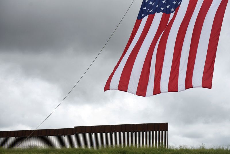 © Reuters. FILE PHOTO: A flag flies in front of a section of the border wall along the U.S.-Mexico border in Pharr, Texas, U.S. June 30, 2021.  REUTERS/Callaghan O'Hare/File Photo