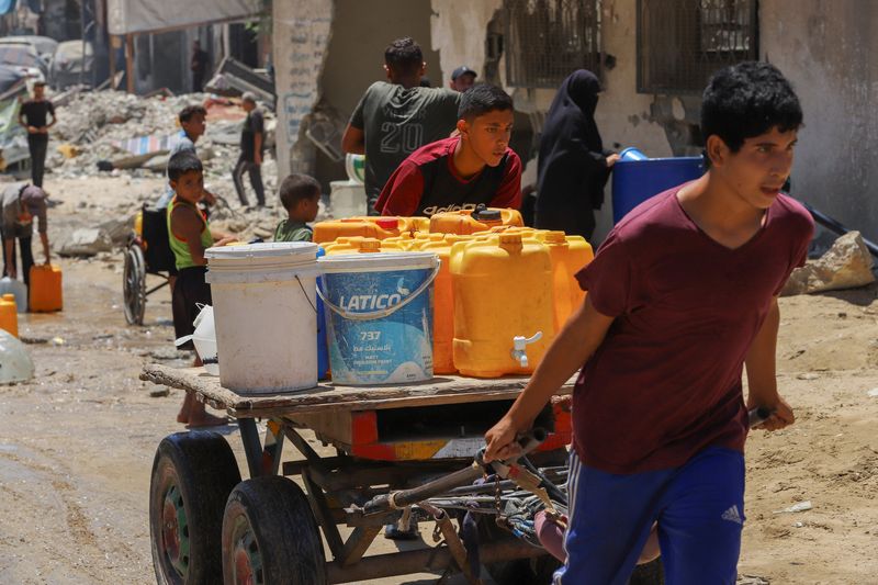 © Reuters. FILE PHOTO: Palestinians gather to collect water amid shortages as the conflict between Israel and Hamas continues, in Khan Younis, southern Gaza Strip, July 29, 2024. REUTERS /Hatem Khaled/File Photo