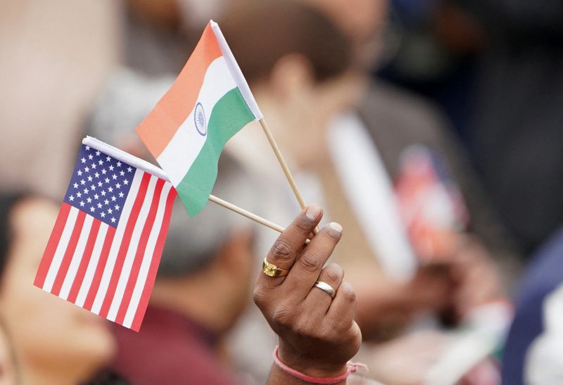 © Reuters. FILE PHOTO: An attendee holds U.S. and India's flags as they gather on the South Lawn of the White House to watch an official State Arrival ceremony as U.S. President Joe Biden hosts India's Prime Minister Narendra Modi for a State Visit at the White House in Washington, U.S., June 22, 2023. REUTERS/Kevin Lamarque/File Photo