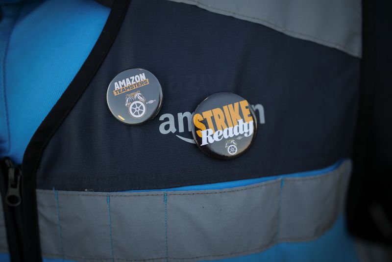 © Reuters. A striking worker wears badges on their Amazon clothing, as they picket outside of the Amazon DAX5 warehouse, in City of Industry, California, U.S., December 19, 2024. REUTERS/Daniel Cole