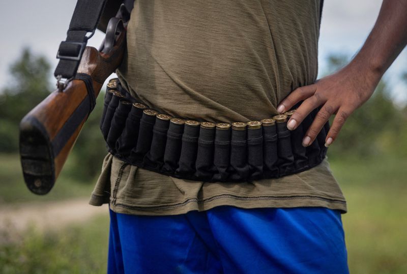 © Reuters. FILE PHOTO: An armed Kuki man stands at a checkpoint at Kangvai village in Churachandpur district in the northeastern state of Manipur, India, July 23, 2023. REUTERS/Adnan Abidi/File Photo