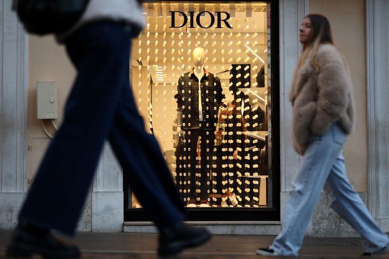 © Reuters. People walk past a Dior shop in Rome, Italy, December 18, 2024. REUTERS/Guglielmo Mangiapane/File Photo