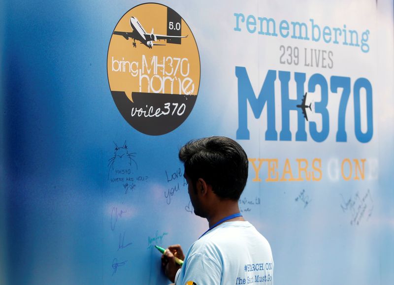 &copy; Reuters. FILE PHOTO: A man writes on a message board for passengers, onboard the missing Malaysia Airlines Flight MH370, during its fifth annual remembrance event in Kuala Lumpur, Malaysia March 3, 2019. REUTERS/Lai Seng Sin/File Photo