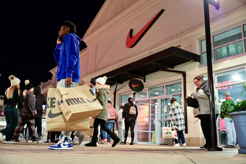 &copy; Reuters. A man with Nike bags talks on the phone in front of a Nike store as Black Friday sales begin at The Outlet Shoppes of the Bluegrass in Simpsonville, Kentucky, U.S., November 26, 2021. REUTERS/Jon Cherry/File Photo