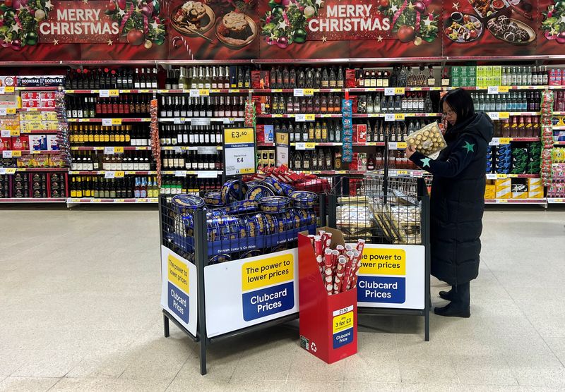 © Reuters. FILE PHOTO: A customer looks at chocolates for sale in a Christmas offers aisle in a Tesco supermarket in Manchester, Britain, December 19, 2024. REUTERS/Phil Noble/File Photo