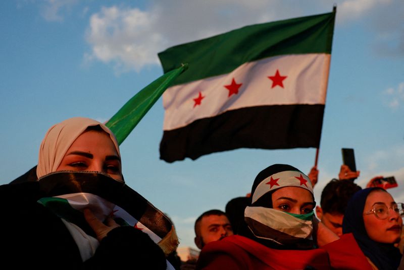 © Reuters. FILE PHOTO: A person waves a flag adopted by the new Syrian rulers, as people gather during a celebration called by Hayat Tahrir al-Sham (HTS) near the Umayyad Mosque, after the ousting of Syria's Bashar al-Assad, in Damascus, Syria, December 20, 2024. REUTERS/Ammar Awad/File Photo