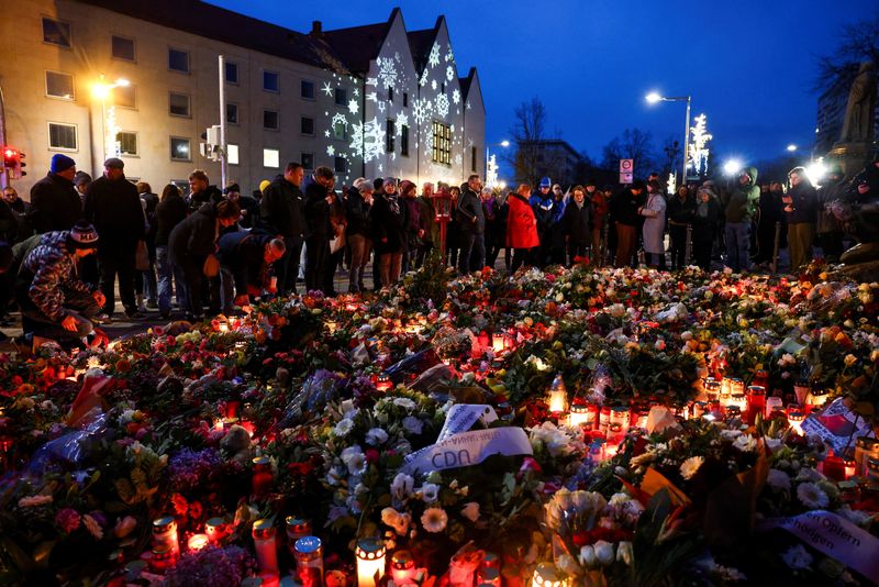 &copy; Reuters. Brinquedos de pelúcia, velas e flores colocados próximos do local onde um carro atropelou uma multidão em um mercado de Natal, em Magdeburgn21/12/2024nREUTERS/Christian Mang