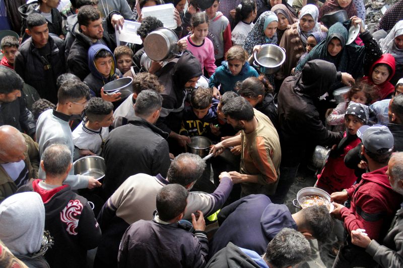 © Reuter. PHOTO DE DOSSIER : Les Palestiniens se rassemblent pour recevoir de la nourriture gratuite alors que les habitants de Gaza sont confrontés à des niveaux de faim criants, pendant le mois sacré du Ramadan, au milieu du conflit en cours entre Israël et le Hamas, à Jabalia, dans le nord de la bande de Gaza, le 19 mars 2024. REUTERS/Mahmoud Issa /Photo de fichier