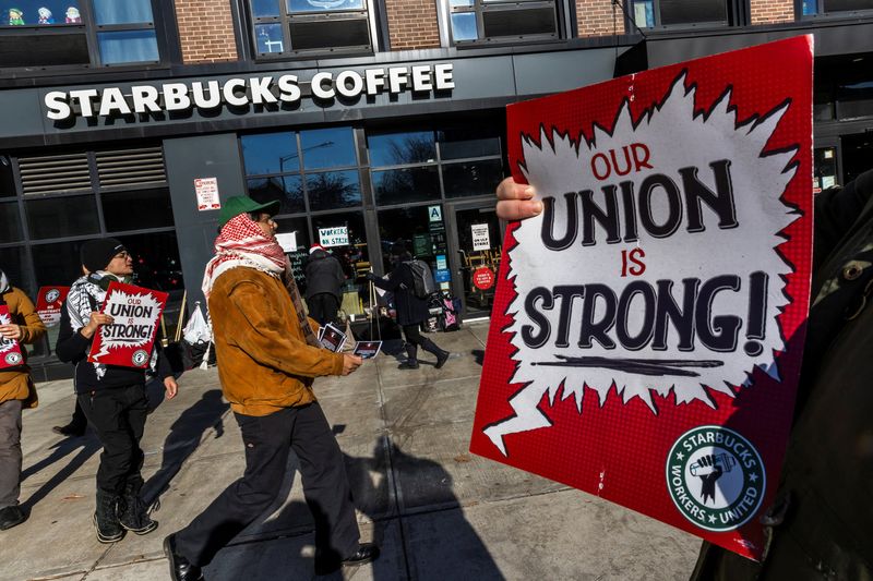 © Reuters. Workers picket in front of a Starbucks in the Brooklyn borough in New York, U.S. December 23, 2024. REUTERS/Eduardo Munoz