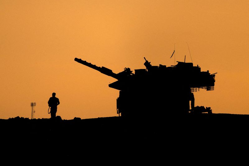 © Reuters. FILE PHOTO: The silhouettes of a military vehicle and a soldier are seen near the Gaza border, amid the ongoing conflict in Gaza between Israel and Hamas, Israel December 16, 2024. REUTERS/Amir Cohen/File Photo