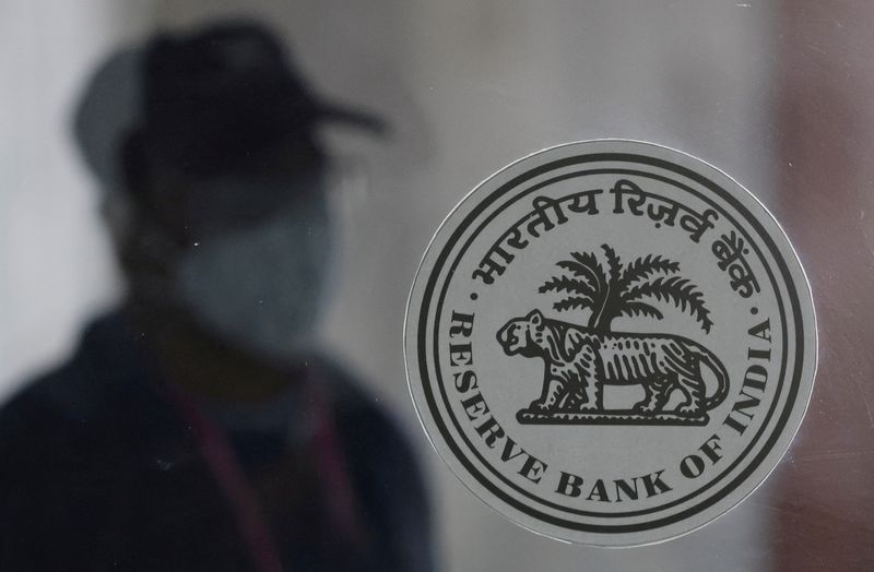 © Reuters. FILE PHOTO: A man walks behind the Reserve Bank of India (RBI) logo inside its headquarters in Mumbai, India, April 8, 2022. REUTERS/Francis Mascarenhas/File Photo