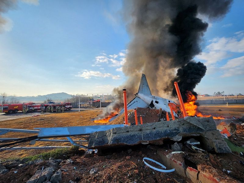 © Reuters. Firefighters carry out extinguishing operations on an aircraft which drove off runaway at Muan International Airport in Muan, South Jeolla Province, South Korea, December 29, 2024. Yonhap via REUTERS