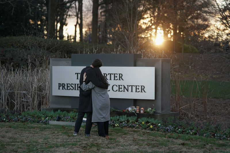 © Reuters. A couple stands in front of The Carter Presidential Center's sign, after the death of former U.S. President Jimmy Carter at the age of 100, in Atlanta, Georgia, U.S., December 29, 2024. REUTERS/Elijah Nouvelage