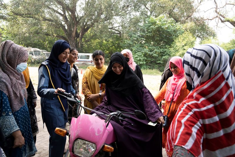 &copy; Reuters. Humaira Rafaqat, a senior traffic warden, teaches women how to ride a bike while wearing an abaya, during a training session as part of the "Women on Wheels" program organised by the traffic police department in Lahore, Pakistan, October 1, 2024. REUTERS/