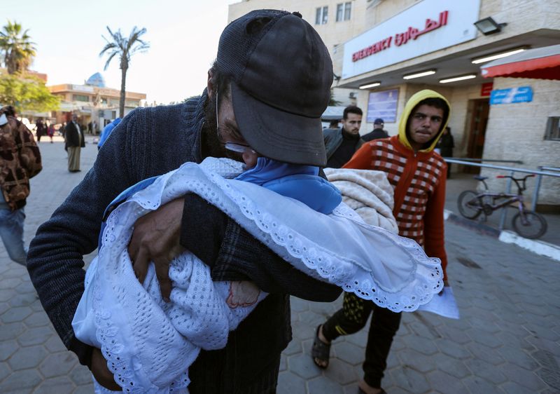 © Reuters. Yahya Al-Batran, the father of Palestinian infant Jumaa Al-Batran, who died of hypothermia after living in a tent with his displaced family, reacts as he embraces his body at Al-Aqsa Martyrs Hospital, in Deir Al-Balah in the central Gaza Strip, December 29, 2024. REUTERS/Ramadan Abed