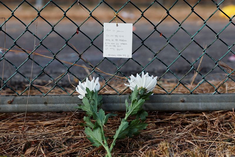 &copy; Reuters. Flores e mensagem de condolências colocadas no local da queda de uma aeronave no aeroporto de Muan, na Coreia do Suln30/12/2024 REUTERS/Kim Soo-hyeon