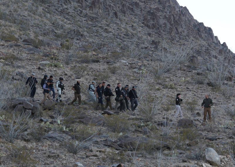 © Reuters. Authorities escort two suspects after the death of a National Migration Institute agent in Samalayuca on the outskirts of Ciudad Juarez, Mexico, on December 30, 2024. REUTERS/Carlos Sanchez TPX Photos of the Day