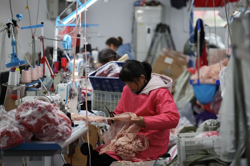 © Reuters. FILE PHOTO: Employees work on the production line at the Midnight Charm Garment lingerie factory in Guanyun county in Lianyungang, Jiangsu province, China, November 25, 2024. REUTERS/Florence Lo/File Photo