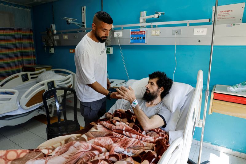 &copy; Reuters. FILE PHOTO: Palestinian Moazaz Obaiyat, who was released from Israeli jail, takes a cup of water, in a hospital in Bethlehem in the Israeli-occupied West Bank July 11, 2024. REUTERS/Mussa Qawasma/File Photo