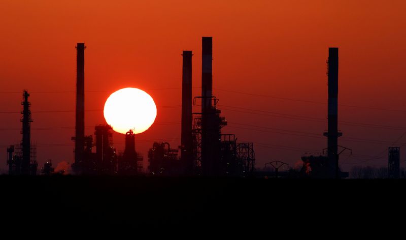 © Reuters. The sun sets behind the chimneys of the Total Grandpuits oil refinery, southeast of Paris, France, March 1, 2021.  REUTERS/Christian Hartmann/File Photo