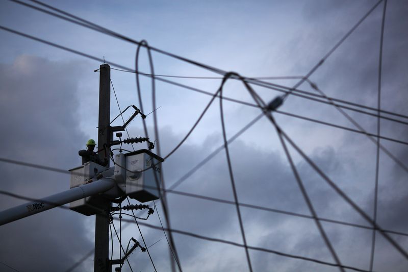 © Reuters. FILE PHOTO: A worker of Puerto Rico's Electric Power Authority (PREPA) repairs part of the electrical grid in Manati, Puerto Rico October 30, 2017. REUTERS/Alvin Baez/File Photo