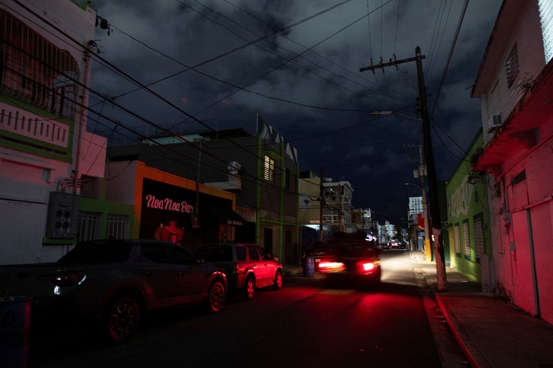 © Reuters. A car drives through a dark street as Puerto Ricans were without electricity early on New Year's Eve after a grid failure left nearly all of the island without power, in San Juan, Puerto Rico December 31, 2024.  REUTERS/Ricardo Arduengo