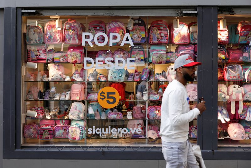 © Reuters. FILE PHOTO: A man walks past a store with a sign reading 