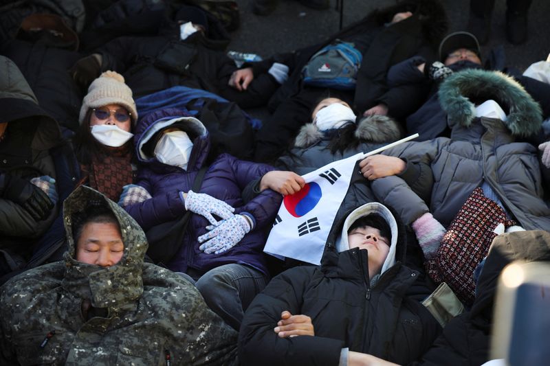 © Reuters. Pro-Yoon protesters lie on the ground outside of impeached South Korean President Yoon Suk Yeol's official residence as police officers attempt to disperse them, as Yoon faces potential arrest after a court on Tuesday approved a warrant for his arrest, in Seoul, South Korea, January 2, 2025. REUTERS/Kim Hong-Ji