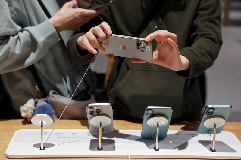 &copy; Reuters. Un uomo guarda un iPhone 16 Pro Max mentre i nuovi smartphone della serie iPhone 16 vengono messi in vendita in un Apple Store di Pechino, in Cina, il 20 settembre 2024. REUTERS/Florence Lo/Foto d'archivio