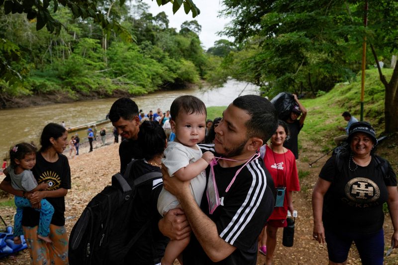 &copy; Reuters. FILE PHOTO: A migrant carries his child after crossing the Darien Gap and arriving at the migrant reception center, in the village of Lajas Blancas, Darien Province, Panama, September 26, 2024. REUTERS/Enea Lebrun/File Photo