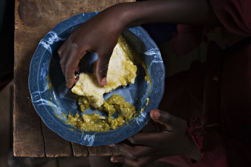 © Reuters. FILE PHOTO: A schoolboy eats a plate of food provided by the United Nations World Food Programme (WFP) at the New Hope Kibera Bible Baptist Church Primary School in Nairobi's Kibera slum, June 2, 2009. REUTERS/Finbarr O'Reilly/ File Photo