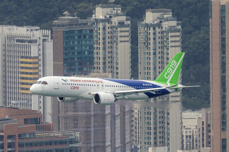 © Reuters. FILE PHOTO: China's first domestically manufactured passenger aircraft Comac C919 flies over Victoria Harbour during its inaugural voyage outside the mainland, in Hong Kong, China December 16, 2023. REUTERS/Tyrone Siu/File Photo