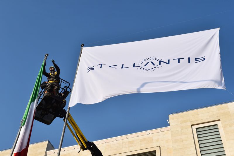 &copy; Reuters. Operai installano una bandiera con il logo di Stellantis all'ingresso principale dello stabilimento FCA di Mirafiori a Torino, Italia, 18 gennaio 2021. REUTERS/Massimo Pinca/Foto d'archivio