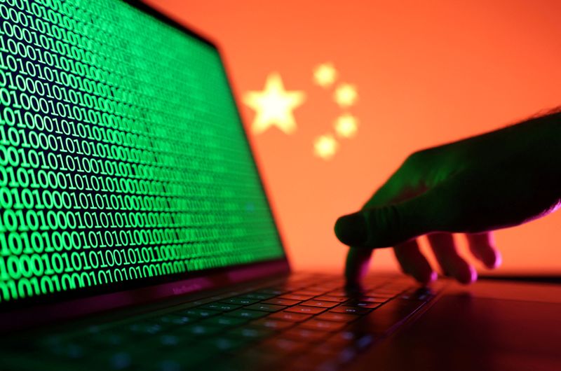 © Reuters. FILE PHOTO: A hand is seen on a laptop with binary codes displayed in front of the Chinese flag in this illustration taken, August 19, 2022. REUTERS/Dado Ruvic/Illustration/File Photo