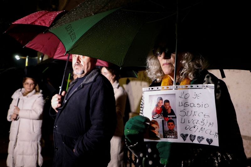 © Reuters. A woman holds a banner with pictures of victims during a protest as the government convenes the National Security Council after a gunman in Cetinje killed several people on a rampage, in Podgorica Montenegro, January 3, 2025. REUTERS/Stevo Vasiljevic