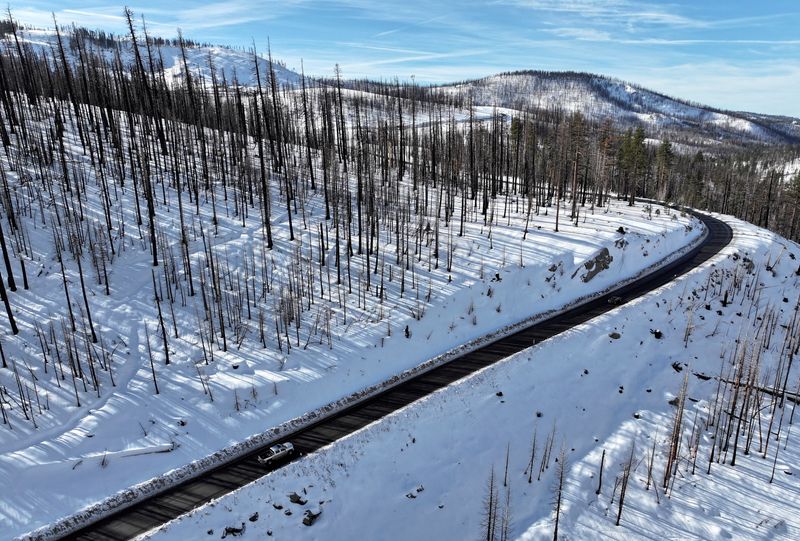 © Reuters. FILE PHOTO: A drone view of cars driving along a road near snow on the ground in Twin Bridges, California, U.S. January 2, 2025.  REUTERS/Fred Greaves/File Photo