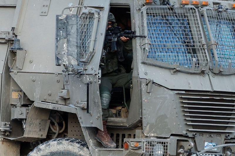 © Reuters. FILE PHOTO: An Israeli soldier holds a weapon in a military vehicle, during an Israeli raid in Tulkarm in the Israeli-occupied West Bank October 31, 2024. REUTERS/Raneen Sawafta/File Photo