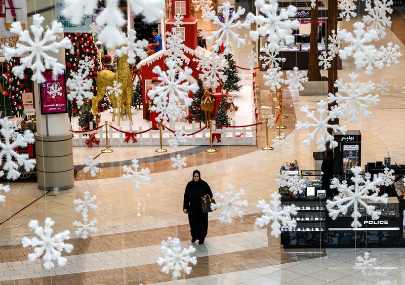 © Reuters. A woman walks through a mall under Christmas decorations in Abu Dhabi, United Arab Emirates, January 12, 2019. Andrew Caballero Reynolds/Pool via Reuters/File photo