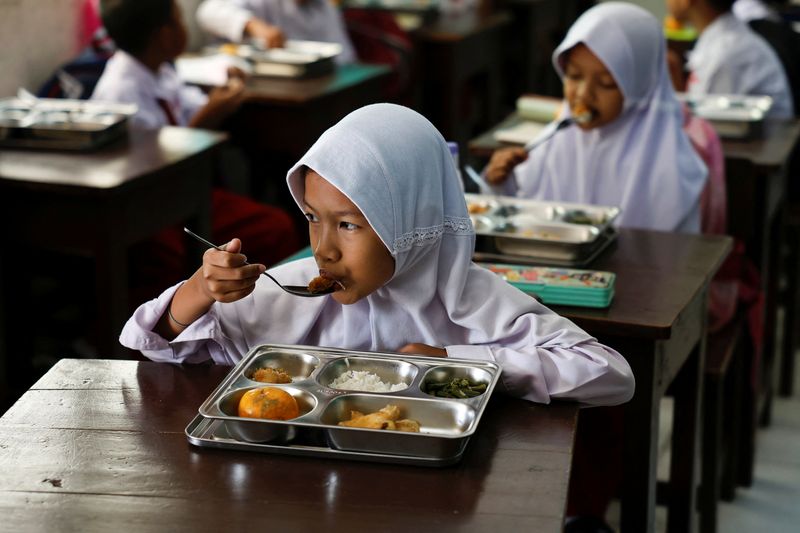 © Reuters. Students eat meals from the free nutritious meals program at a school in Jakarta, Indonesia, January 6, 2025. REUTERS/Willy Kurniawan