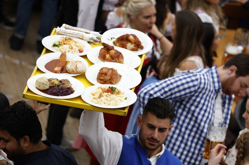 &copy; Reuters. Un cameriere porta i piatti con il cibo durante l'apertura ufficiale del più grande festival della birra del mondo, il 187° Oktoberfest a Monaco, Germania, 17 settembre 2022. REUTERS/Michaela Rehle/Foto d'archivio