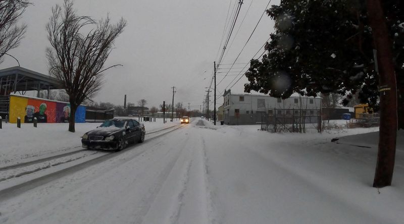 © Reuters. FILE PHOTO: Vehicles drive through the snow as it covers streets in Louisville, Kentucky, U.S., January 5, 2025, in this screen grab obtained from a social media video. Richard Stottman/@cyntrix/via REUTERS 