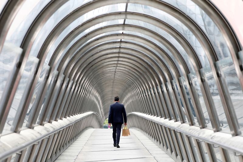 © Reuters. A businessman walks inside the Japanese bridge in the La Défense financial and business district in Potoux, France, May 16, 2018. REUTERS/Charles Platiau/File Photo